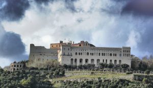 Qui sopra , la Certosa di San Martino e in alto, il Maschio Angioino, tra i luoghi della rassegna. Al centro, la locandina della manifestazione