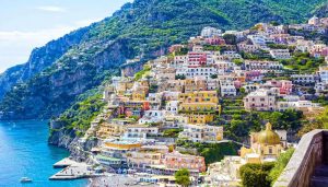 Qui sopra, Positano. In alto, un tramonto napoletano da via Petrarca. Om basso, la penisola sorrentina